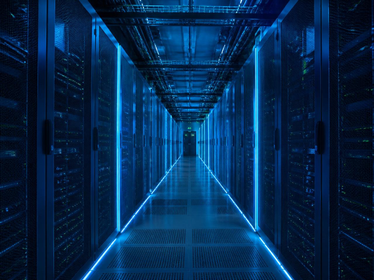 Hyperscale datacentre aisle at blue hour with cyan accent lighting